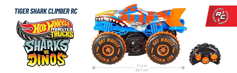 Il testo dice &laquo;TIGER SHARK CLIMBER RC&raquo;. Collezione di giocattoli monster truck Hot Wheels, inclusi veicoli a tema squalo esposti nella confezione del prodotto.